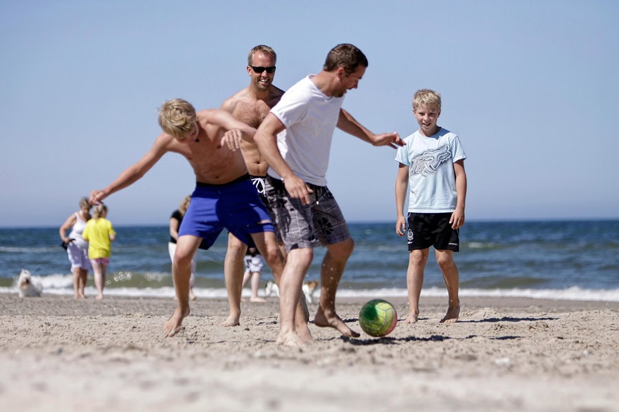 Urlaub mit der Familie am flachen Ostseestrand – Eltern und Kinder am Wasser