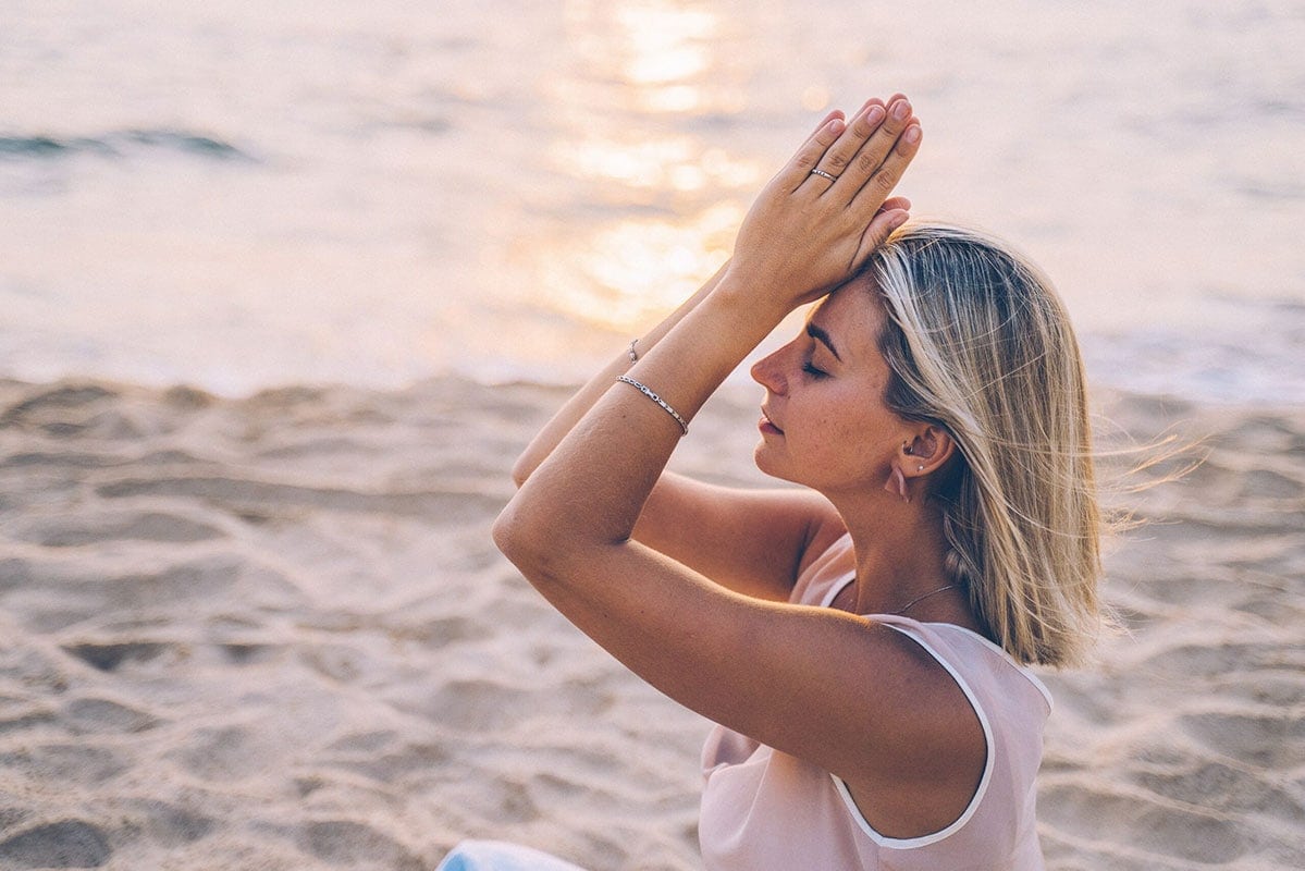 Frau bei einer Yoga-Übung am Ostseestrand von Fischland-Darß